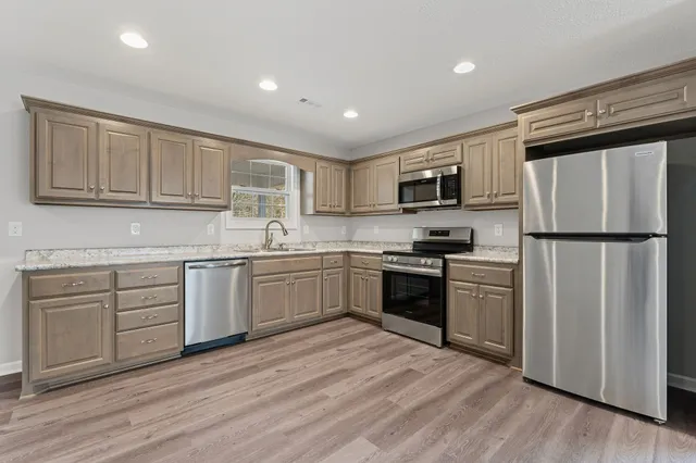 a kitchen with cabinets stainless steel appliances and a sink