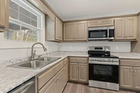 a kitchen with granite countertop cabinets and window
