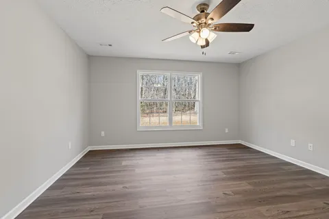 a view of an empty room with wooden floor