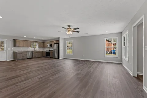 a view of kitchen with granite countertop stainless steel appliances cabinets and wooden floor