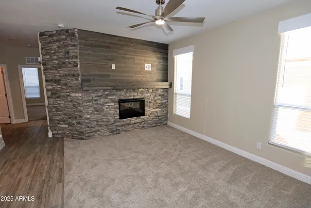 an empty room with windows and fireplace