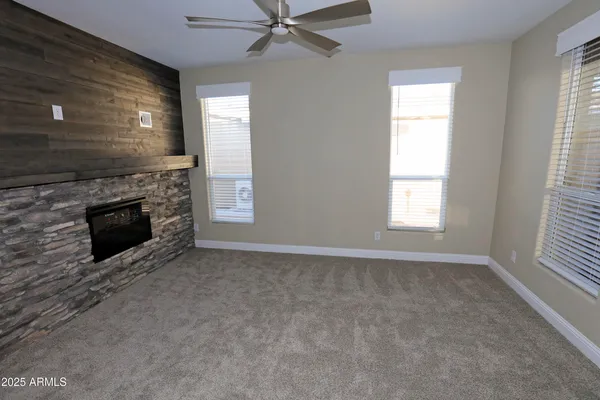 a view of an empty room with a fireplace and a window