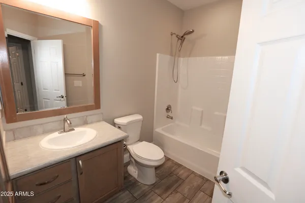 a bathroom with a sink a toilet and a large mirror