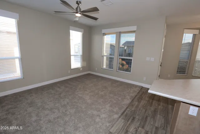 an empty room with windows and fan