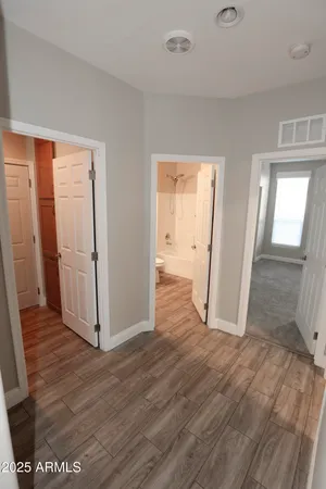 an empty room with wooden floor and entrance