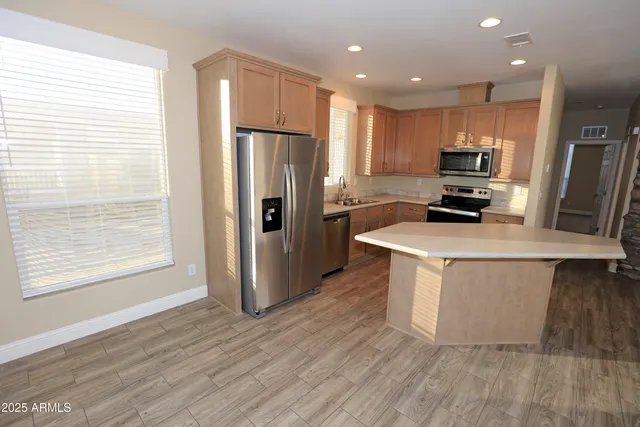 a kitchen with a refrigerator a sink and wooden floor