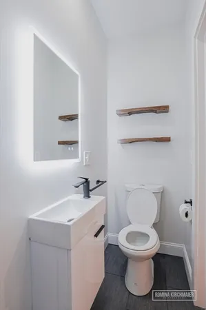 a white toilet sitting next to a bathroom sink