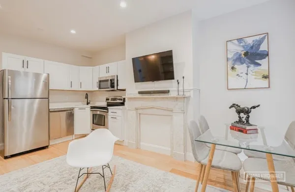a kitchen with white cabinets and stainless steel appliances