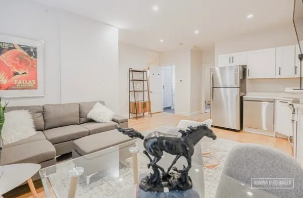 a living room with furniture and a kitchen area