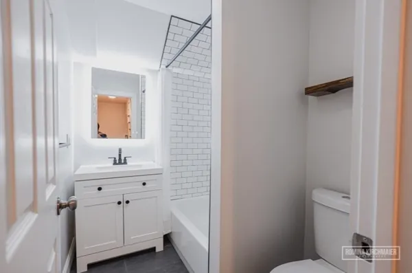 a bathroom with a sink a toilet a mirror and vanity