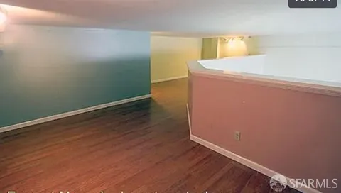 a view of a room with wooden floor and cabinets