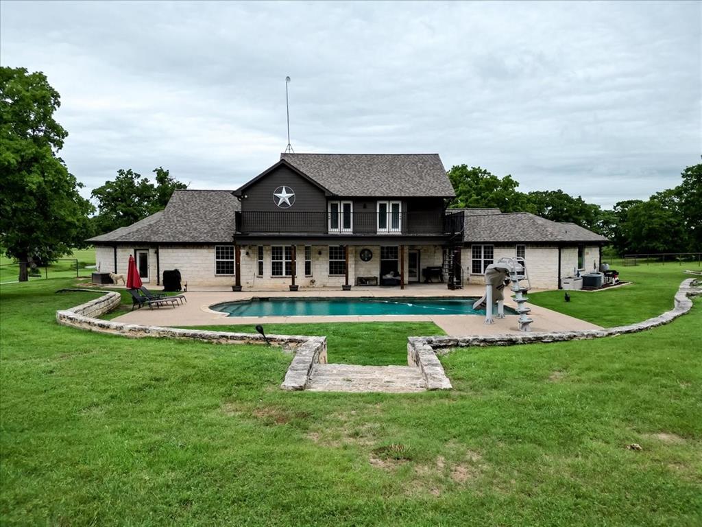 318 East Lone Star Road Poolville, TX 76487 - Photo 2 of 33 a front view of a house with a yard table and chairs