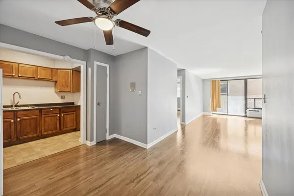 a view of an empty room with window and wooden floor