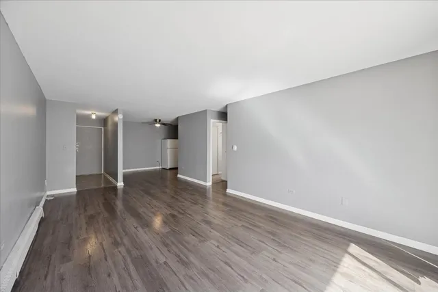 a view of an empty room with wooden floor