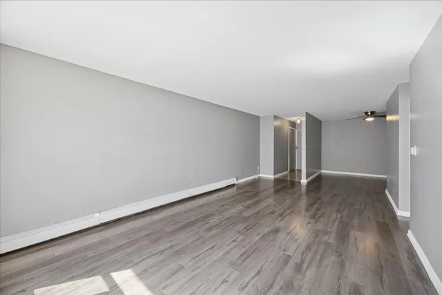a view of an empty room with wooden floor