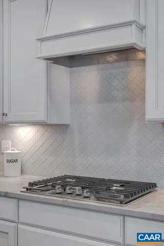 a kitchen with white cabinets and a stove