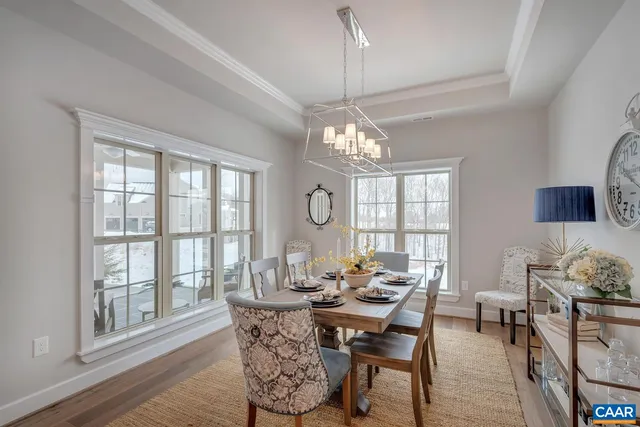 a view of a dining room with furniture a chandelier and wooden floor