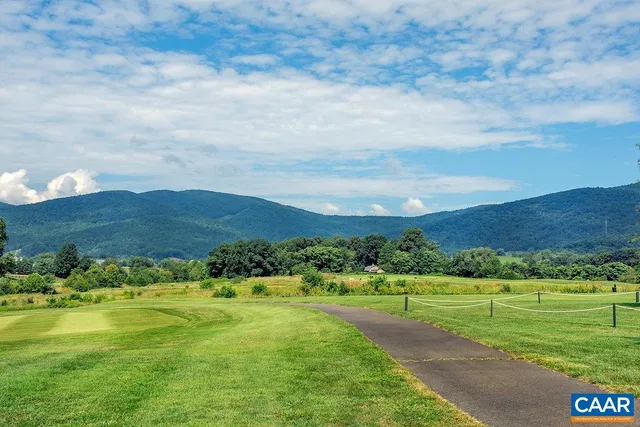 an aerial view of a house with a garden and lake view