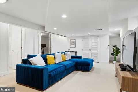 a living room with furniture kitchen view and a flat screen tv
