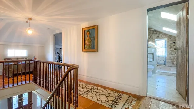 a view of hallway with a window and wooden floor