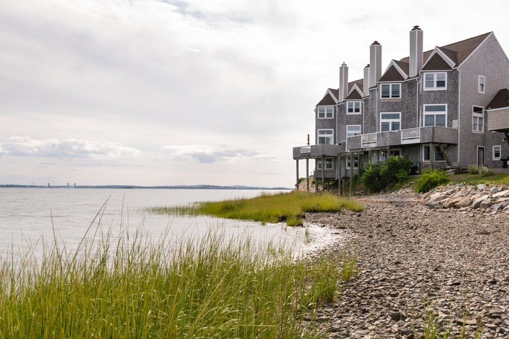 16 Marina Drive, Unit 16 Hull, MA 02045 - Photo 18 of 22 a view of a lake with a big yard and large trees