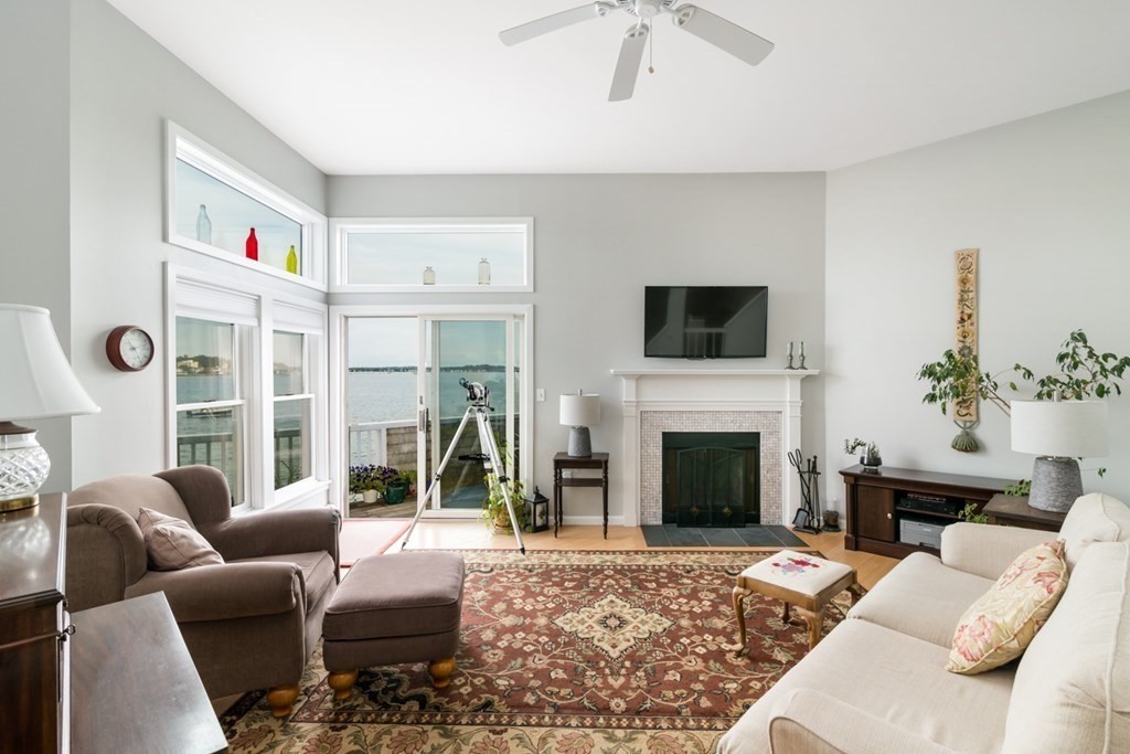 16 Marina Drive, Unit 16 Hull, MA 02045 - Photo 3 of 22 a living room with furniture a fireplace and a floor to ceiling window