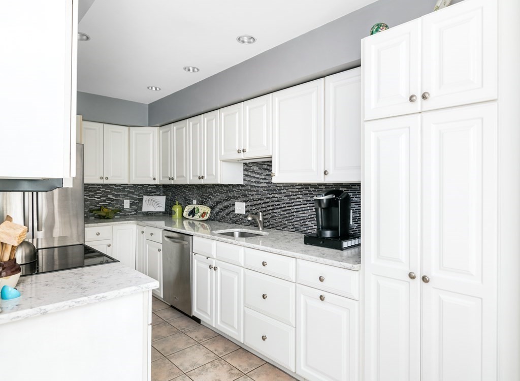 16 Marina Drive, Unit 16 Hull, MA 02045 - Photo 6 of 22 a kitchen with granite countertop white cabinets and white appliances