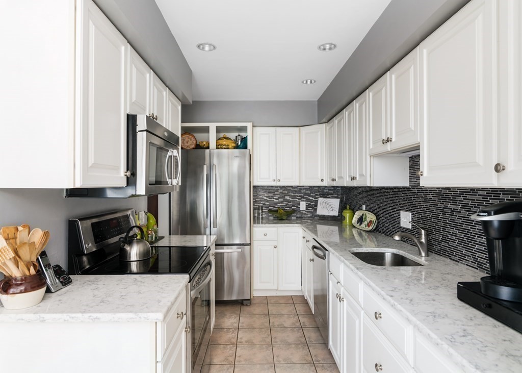 16 Marina Drive, Unit 16 Hull, MA 02045 - Photo 7 of 22 a kitchen with stainless steel appliances granite countertop a refrigerator sink and stove