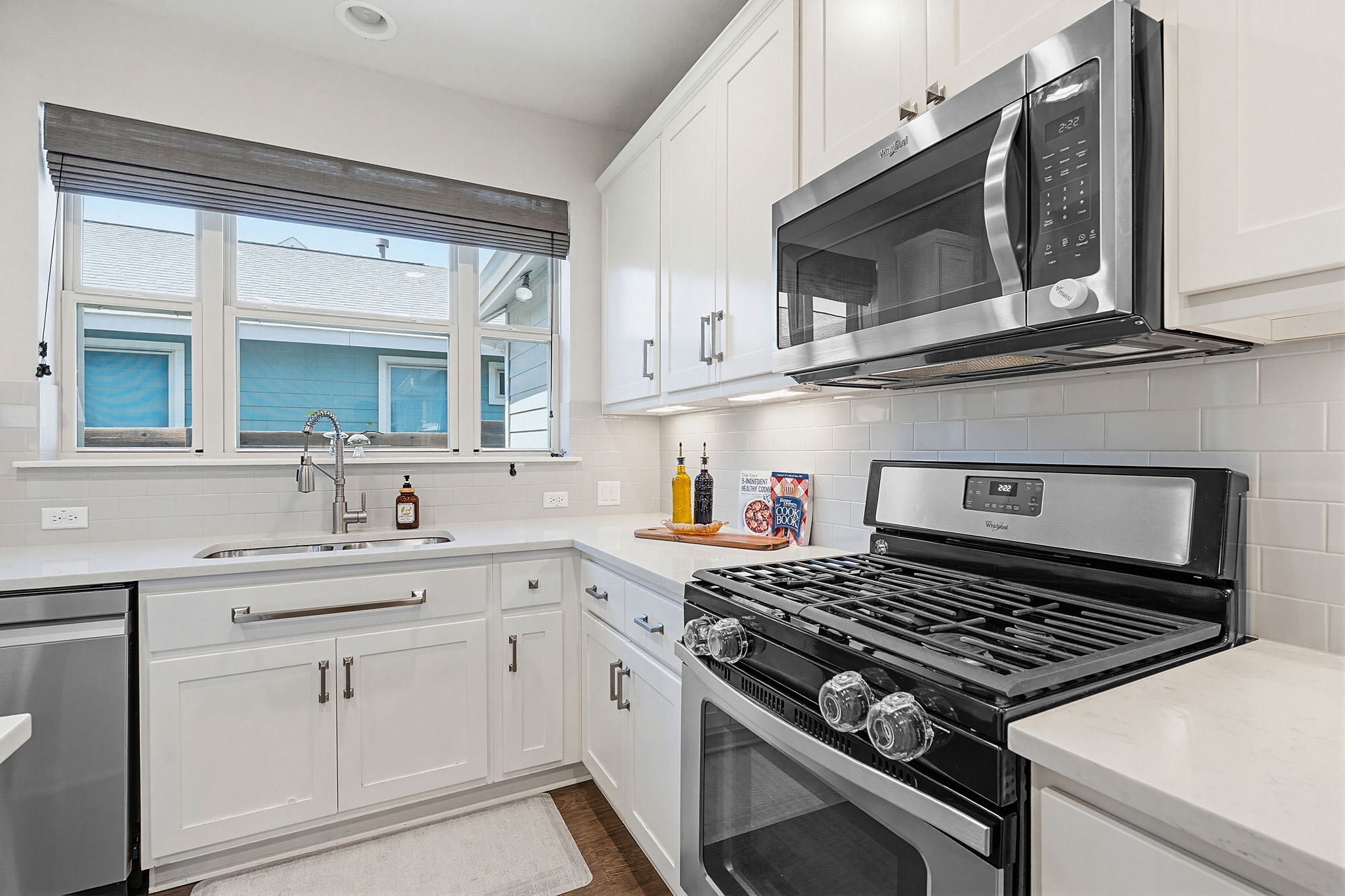 5820 Baythorne Drive Austin, TX 78747 - Photo 12 of 32 a kitchen with stainless steel appliances a sink dishwasher a stove and white cabinets