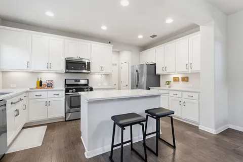 a kitchen with cabinets stainless steel appliances and a window