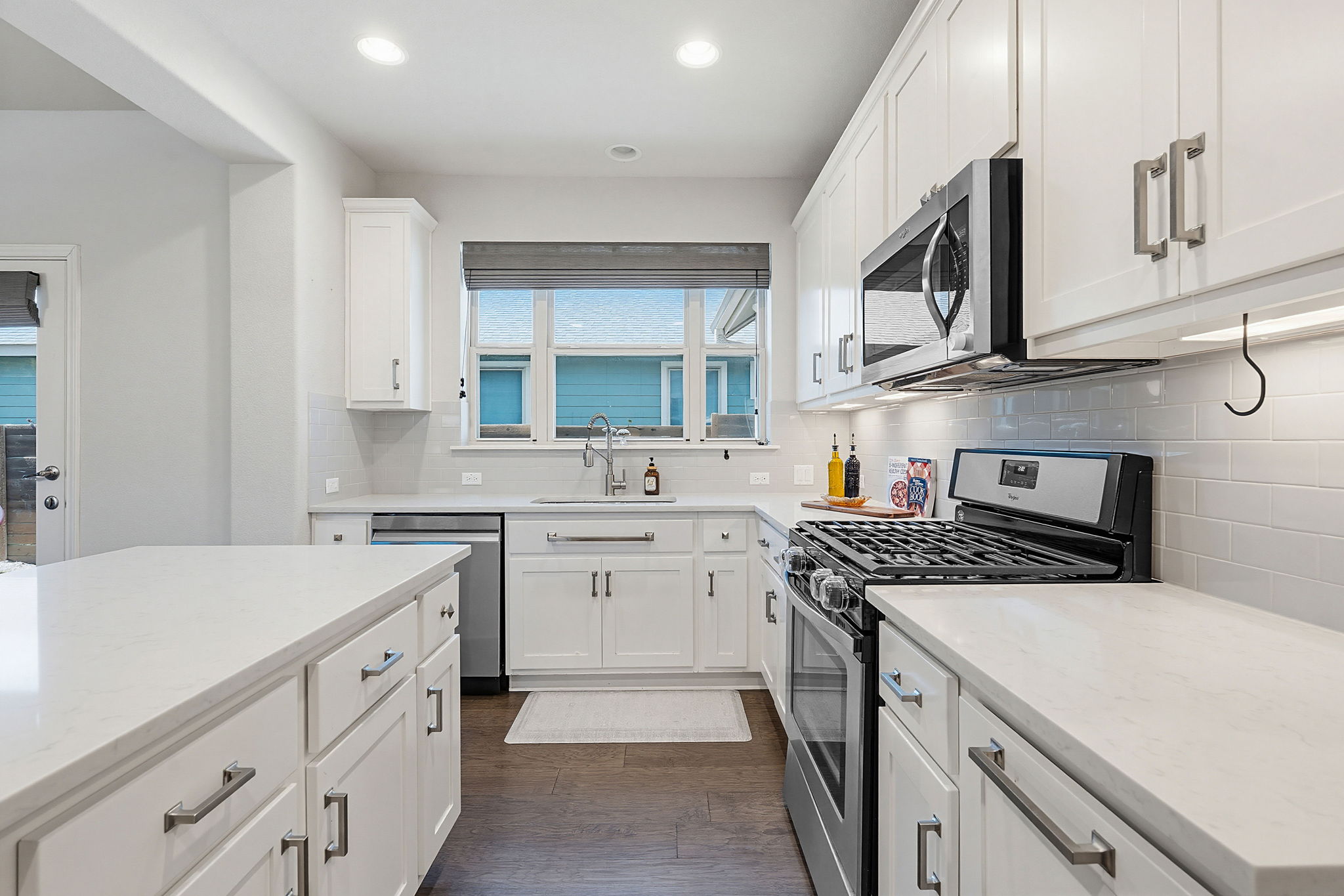 5820 Baythorne Drive Austin, TX 78747 - Photo 5 of 32 a kitchen with stainless steel appliances granite countertop a sink stove oven and white cabinets