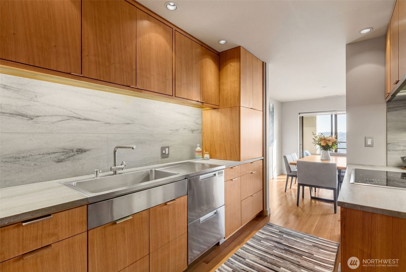 2021 1st Avenue, Unit E8 Seattle, WA 98121 - Photo 16 of 32 a kitchen with a sink cabinets and wooden floor