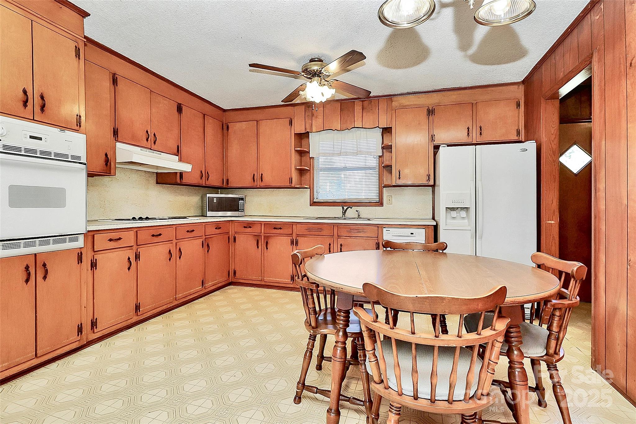 6217 Stack Road Monroe, NC 28112 - Photo 11 of 37 a kitchen with stainless steel appliances granite countertop a sink dishwasher a stove a refrigerator with a dining table and chairs
