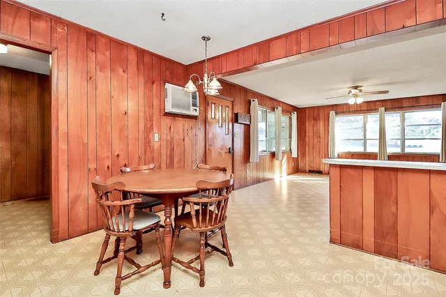 a kitchen with stainless steel appliances kitchen island granite countertop a dining table chairs sink and cabinets