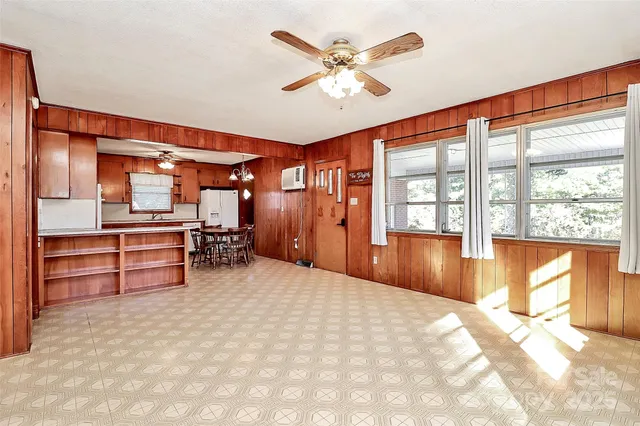 a kitchen with kitchen island granite countertop a sink cabinets and refrigerator