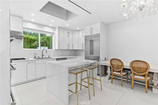 a kitchen with kitchen island white cabinets and stainless steel appliances
