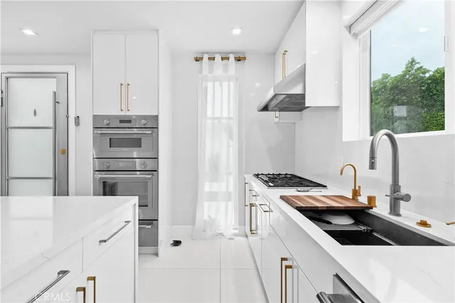 a kitchen that has a sink stove and refrigerator