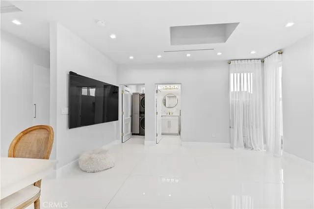 a room with stainless steel appliances kitchen island granite countertop furniture and a large window