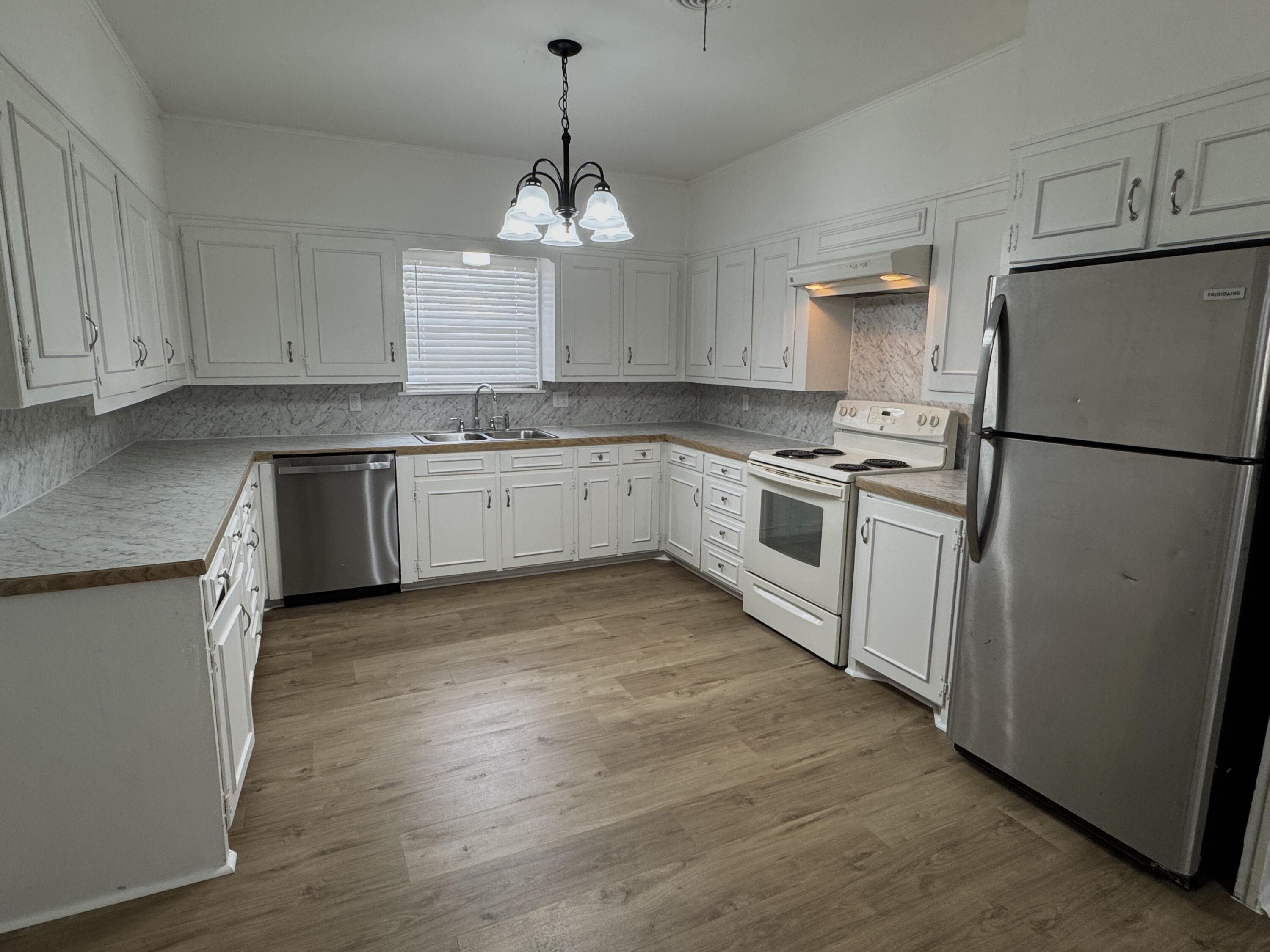 1209 Garland Plainview, TX 79072 - Photo 12 of 38 a kitchen with granite countertop stainless steel appliances a refrigerator a stove a sink and white cabinets