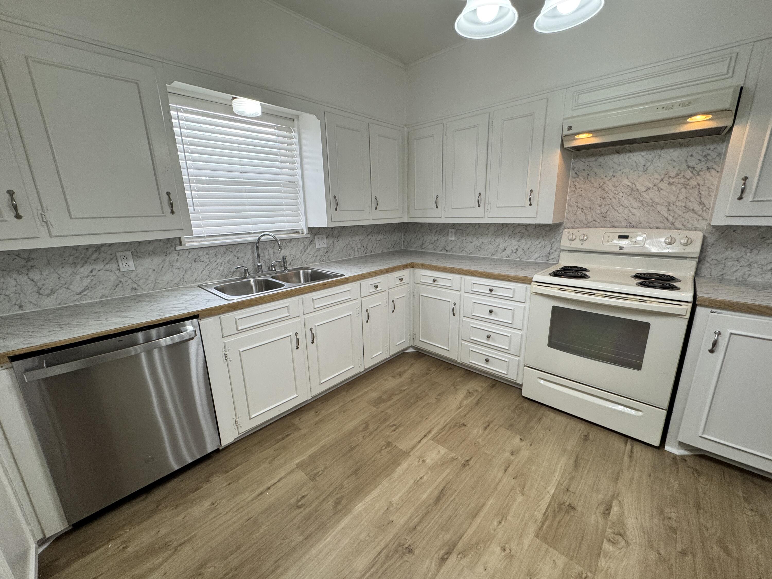 1209 Garland Plainview, TX 79072 - Photo 13 of 38 a kitchen with granite countertop white cabinets sink and stainless steel appliances