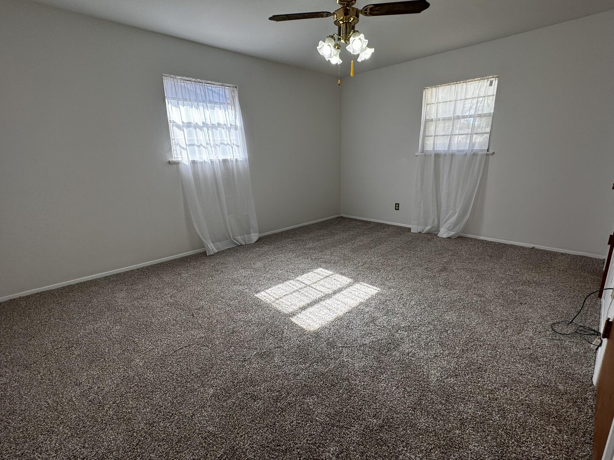 1209 Garland Plainview, TX 79072 - Photo 18 of 38 an empty room with windows and chandelier fan