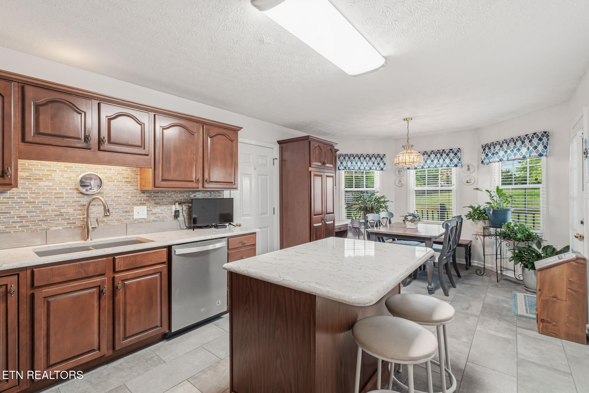 7030 Westerly Winds Road Knoxville, TN 37931 - Photo 16 of 40 a kitchen with a table chairs sink and cabinets
