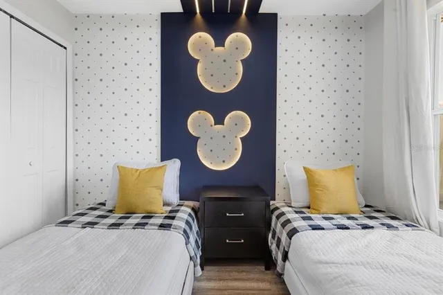 a bedroom with a bed and a lamp on dresser