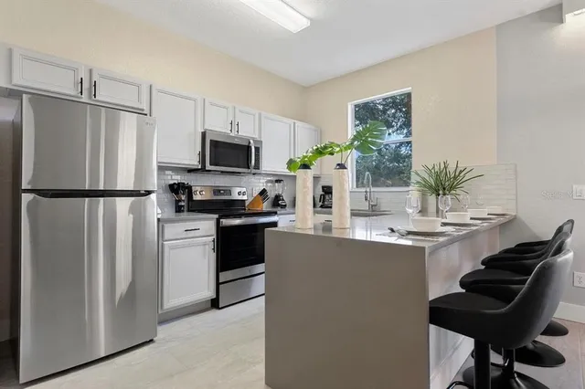 a kitchen with a refrigerator and a stove top oven
