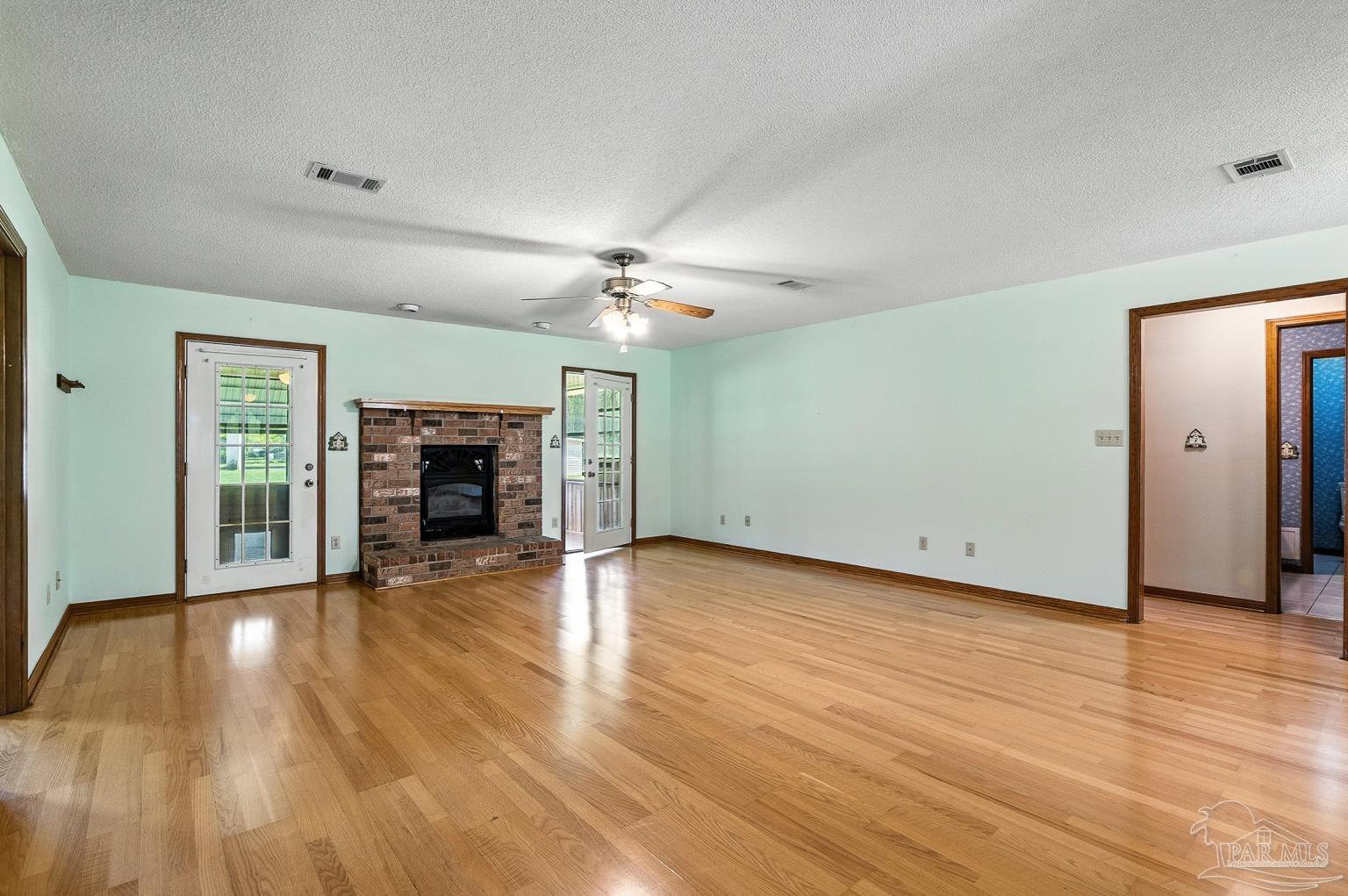 6160 Saddle Club Road Pace, FL 32571 - Photo 15 of 49 a view of a livingroom with wooden floor a ceiling fan and window