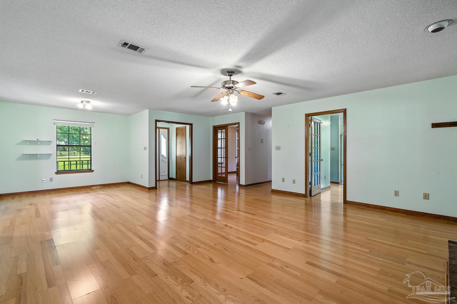 6160 Saddle Club Road Pace, FL 32571 - Photo 18 of 49 a view of an empty room with window and wooden floor