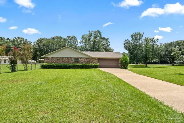 a view of a house with a yard and basketball court