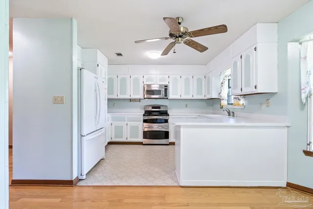 a kitchen with white cabinets and stainless steel appliances
