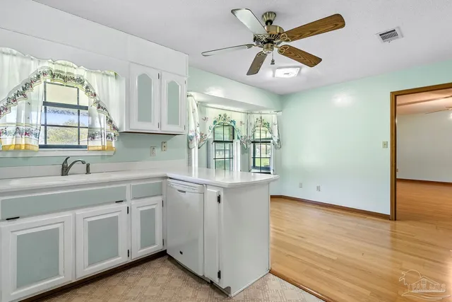 a kitchen with white cabinets and white appliances