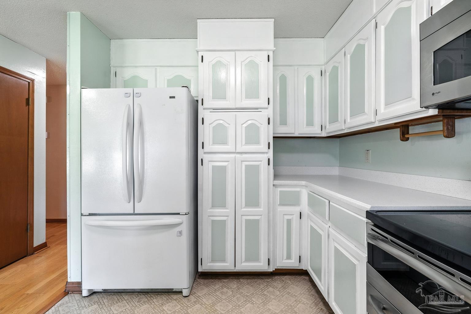 6160 Saddle Club Road Pace, FL 32571 - Photo 26 of 49 a kitchen with white cabinets and white appliances